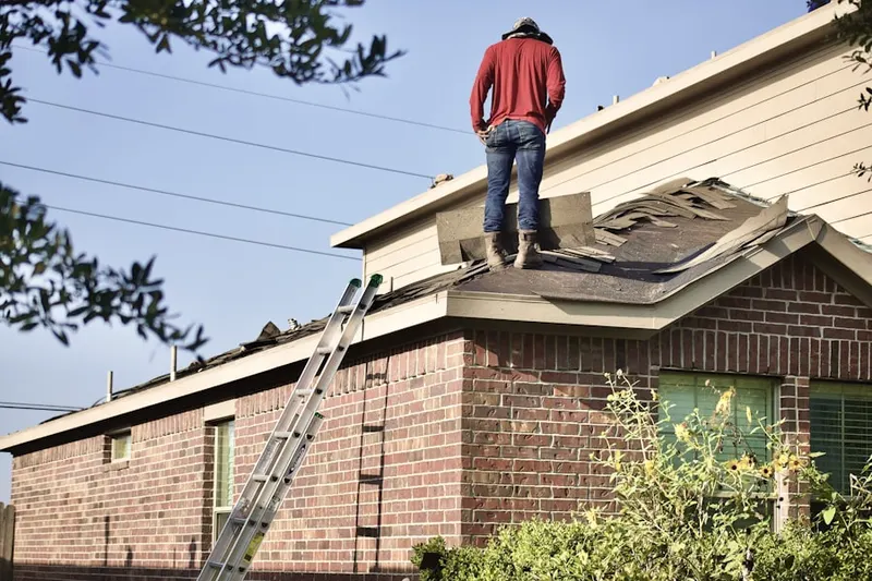 Professional roofer working on a residential roof in Eddington Farms
